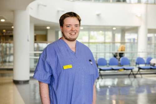 Eddy the intern is in our atrium wearing scrubs.